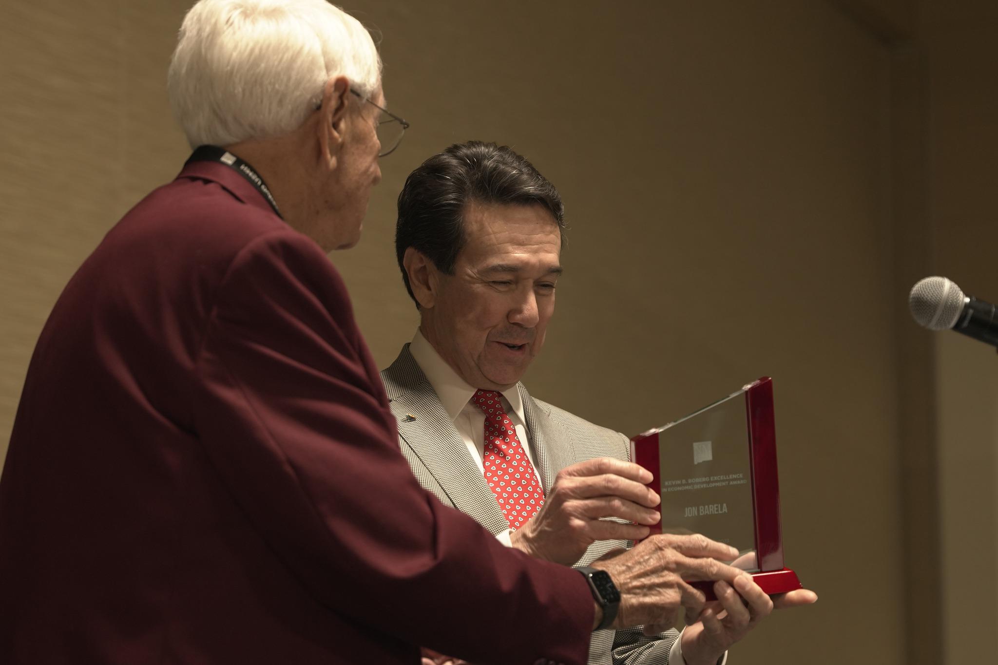 Jon Barela receives an award statue from former 十大电子游戏平台 Chancellor Garrey Carruthers